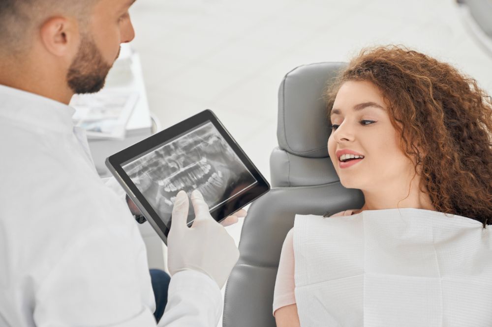 a dentist is showing dental implants report to a lady