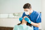 a dentist is checking a patient for a tooth extraction treatment